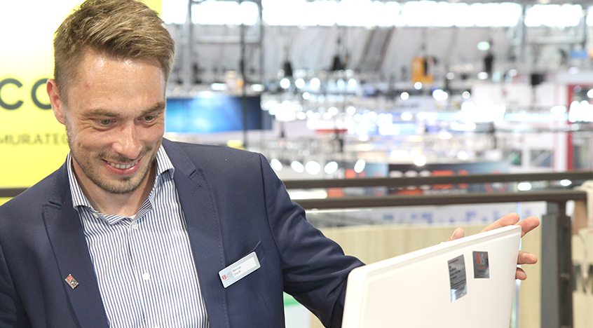 BVS-Mitarbeiter Marcus Stürzl erklärt eine Verpackungslösung an einer Anlage während der LogiMAT Messe